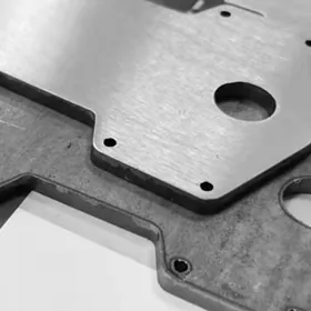 Metal workpiece showing hairline surface finish from deburring